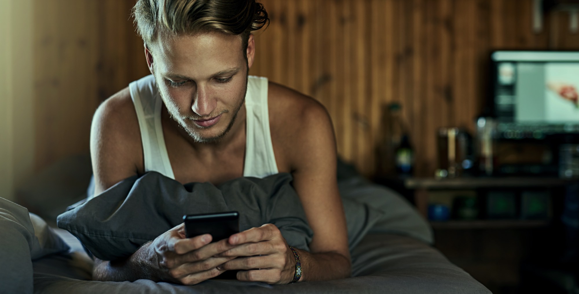 guy-in-bed-boy-man-looking-at-phone-iphone-porn-kills-love