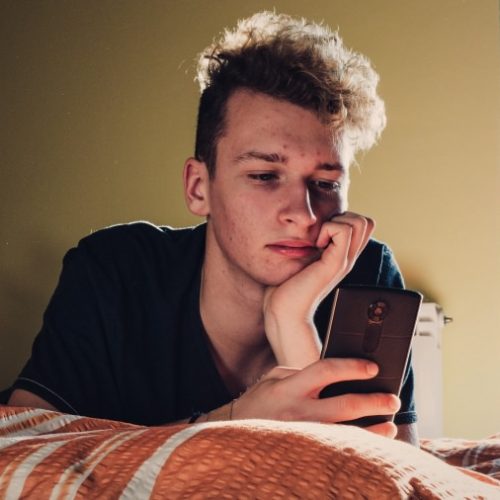 zoomer-millennial-genz-bored-guy-boy-man-teen-phone-in-bedroom
