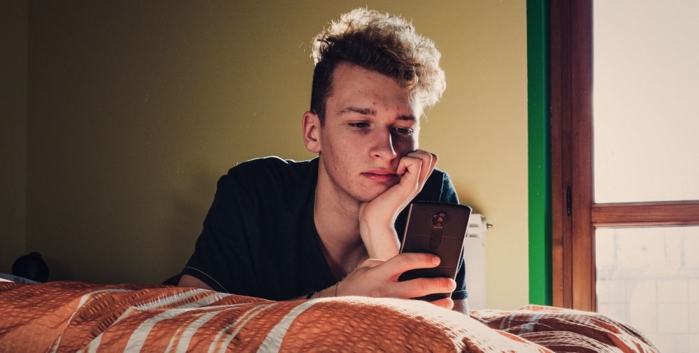 zoomer-millennial-genz-bored-guy-boy-man-teen-phone-in-bedroom